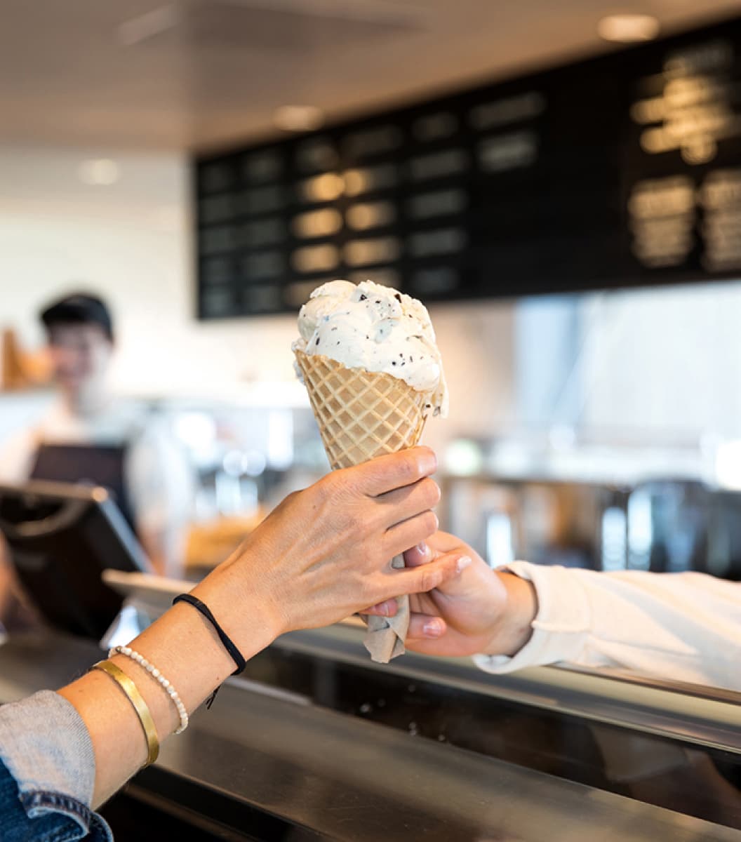 Tillamook employee handing cone to customer
