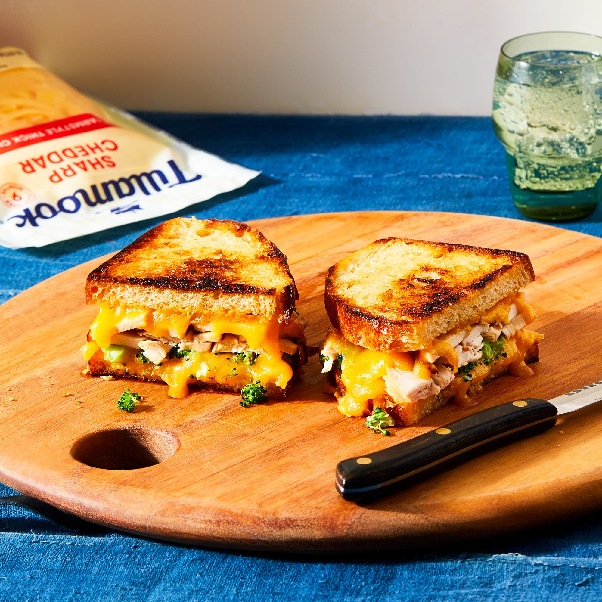 Board with sliced chicken and broccoli panini with Tillamook Sharp Cheddar Shreds